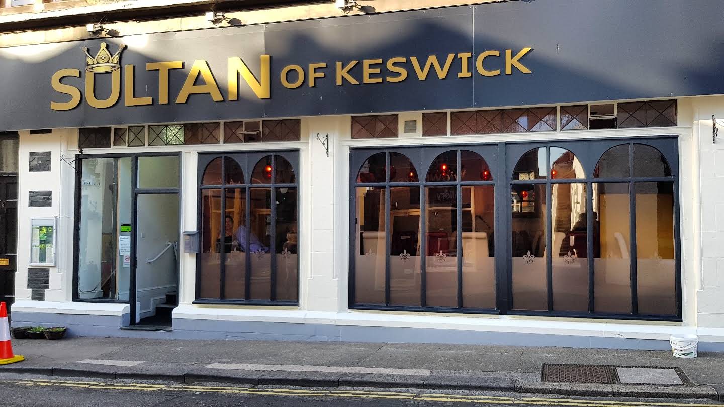The Sultan of Keswick frontage, showing the complete gold-lettered sign, open entrance, doorstep and arched windows